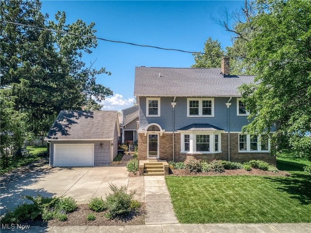 17728 Windward Rd, Cleveland, OH 44119 - view of front of house featuring a garage, a chimney, a front yard, roof with shingles, and concrete driveway