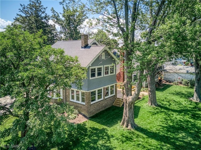 17728 Windward Rd, Cleveland, OH 44119 - back of property featuring a yard, a chimney, and roof with shingles