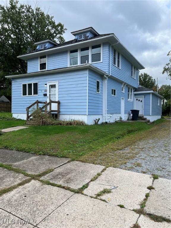 1250 Grant St SE, Warren, OH 44483 - view of side of property with a yard, driveway, and a garage