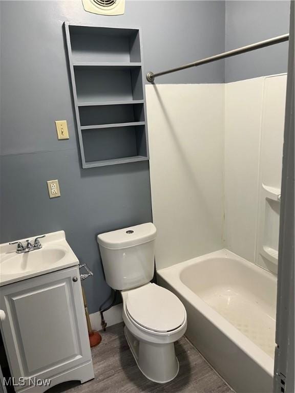 full bathroom with wood-type flooring, shower / washtub combination, vanity, and toilet