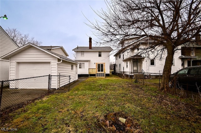 back of property with a garage and a lawn