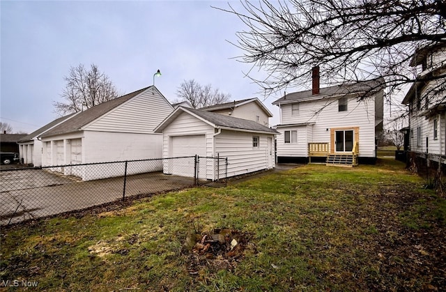 rear view of house featuring a garage and a lawn