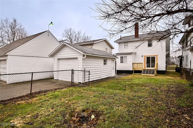 rear view of house featuring a garage and a lawn