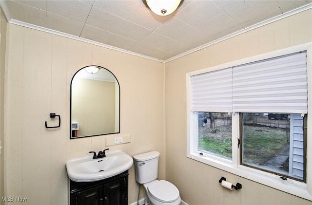 bathroom featuring vanity, ornamental molding, and toilet