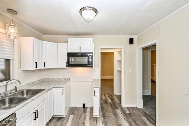 kitchen with pendant lighting, sink, dark wood-type flooring, white cabinetry, and stainless steel dishwasher