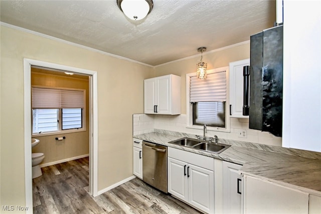 kitchen with sink, dishwasher, hanging light fixtures, light stone counters, and white cabinets