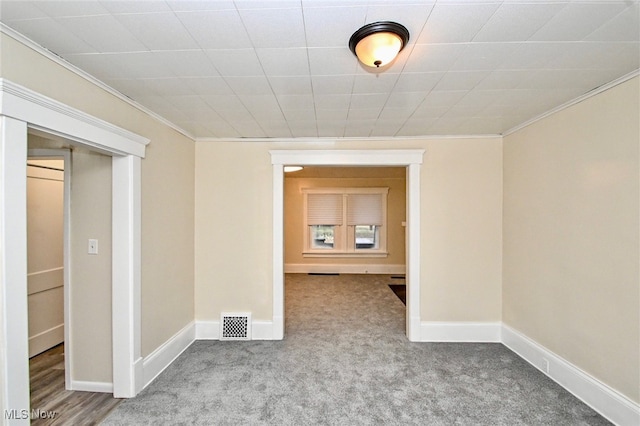 unfurnished room featuring ornamental molding and carpet