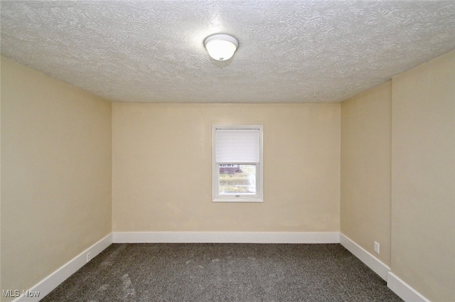 unfurnished room with a textured ceiling and dark colored carpet