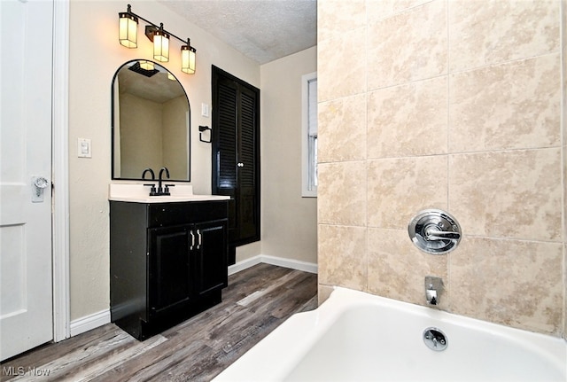 bathroom with vanity, wood-type flooring, and a textured ceiling