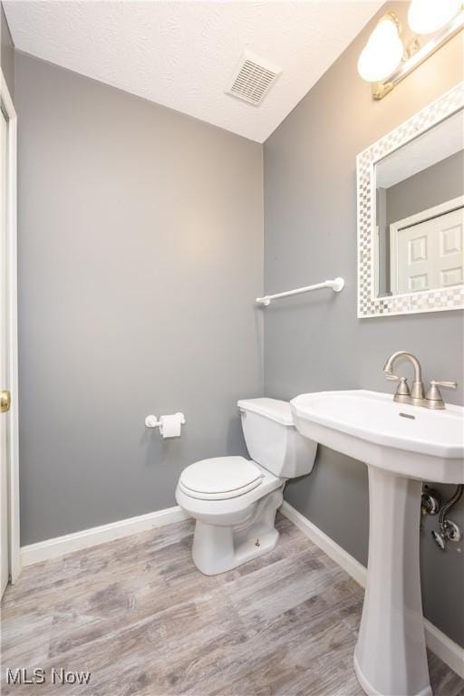 1145 Cookhill Cir, Akron, OH 44312 - bathroom with baseboards, toilet, visible vents, and wood finished floors