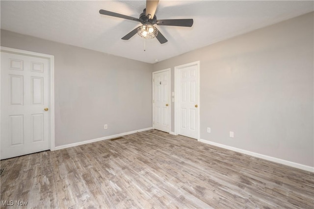 1145 Cookhill Cir, Akron, OH 44312 - unfurnished bedroom featuring baseboards, ceiling fan, and wood finished floors