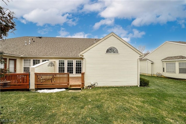 rear view of property featuring a wooden deck and a yard