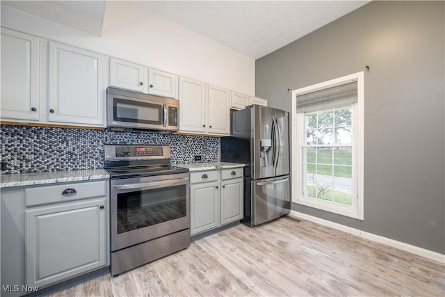 1145 Cookhill Cir, Akron, OH 44312 - kitchen with lofted ceiling, stainless steel appliances, tasteful backsplash, gray cabinets, and light wood-style floors