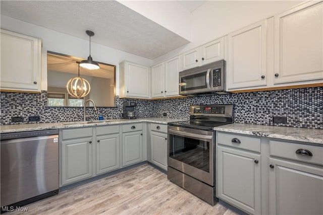 1145 Cookhill Cir, Akron, OH 44312 - kitchen with a sink, tasteful backsplash, a chandelier, gray cabinetry, and appliances with stainless steel finishes