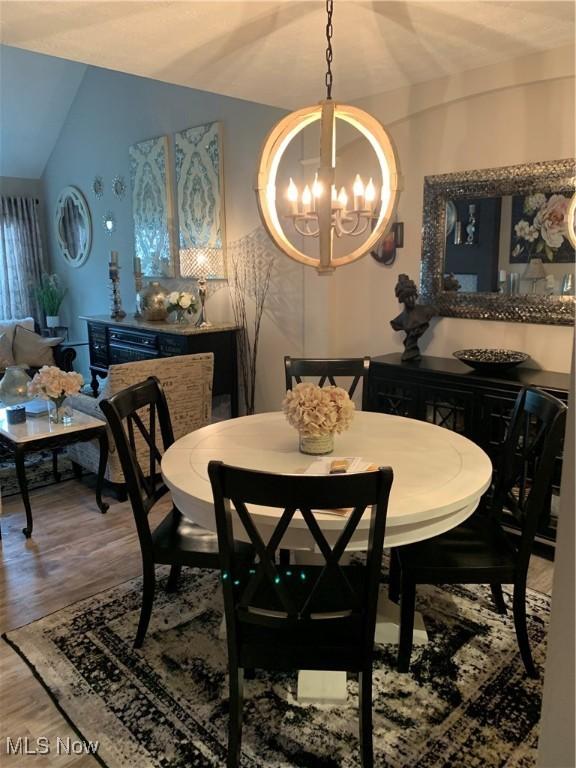1145 Cookhill Cir, Akron, OH 44312 - dining area featuring lofted ceiling, an inviting chandelier, and wood finished floors