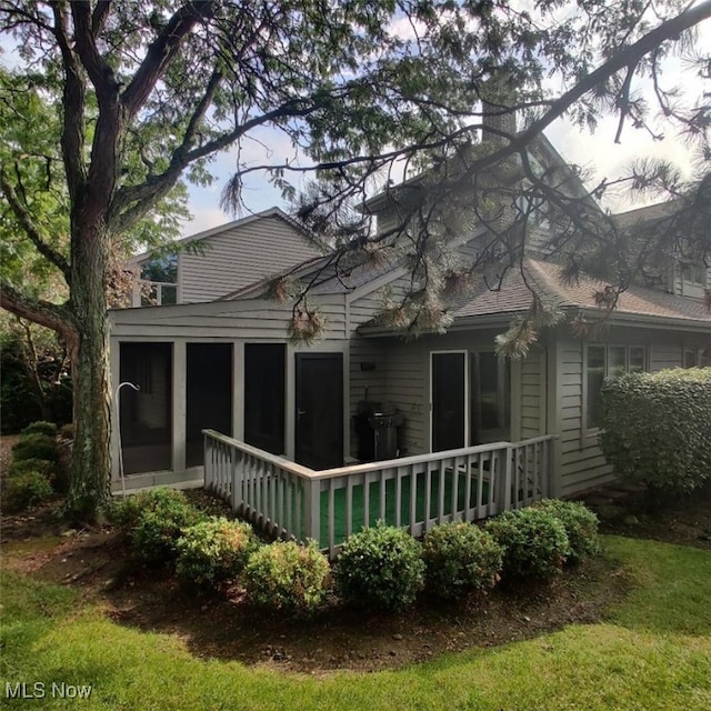 back of property with a sunroom