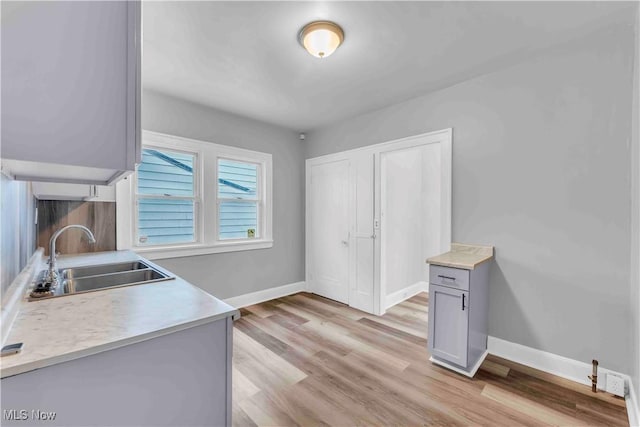 kitchen with sink, light hardwood / wood-style flooring, and gray cabinets