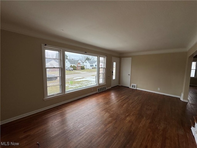 spare room featuring dark hardwood / wood-style flooring and ornamental molding