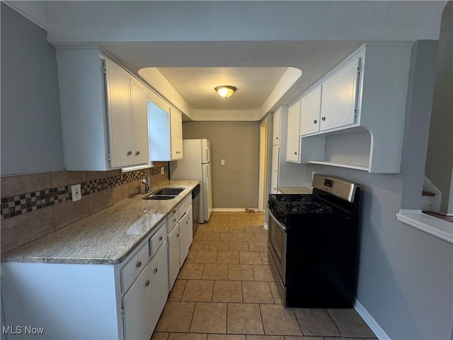 kitchen with light stone countertops, white cabinetry, appliances with stainless steel finishes, and sink