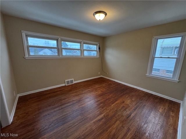 unfurnished room featuring dark wood-type flooring