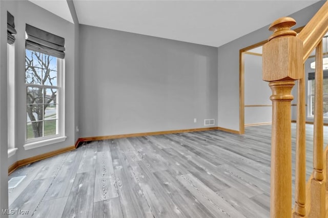 unfurnished room with a wealth of natural light and light hardwood / wood-style flooring