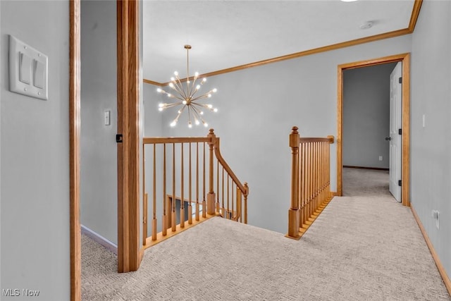 corridor with a notable chandelier, crown molding, and light colored carpet