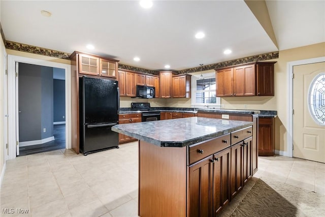 kitchen featuring light tile patterned floors, black appliances, and a center island