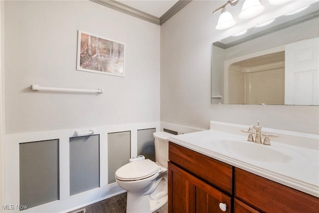 bathroom with ornamental molding, vanity, and toilet