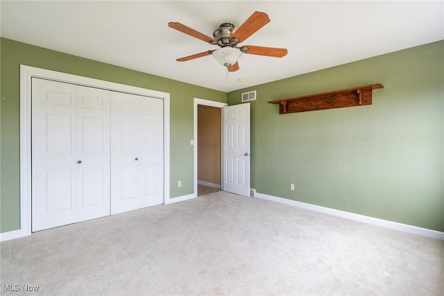 unfurnished bedroom with ceiling fan, carpet flooring, and a closet