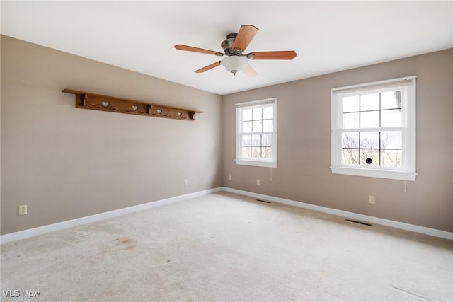 empty room featuring ceiling fan and light carpet