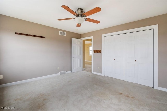 unfurnished bedroom featuring ceiling fan, light colored carpet, and a closet