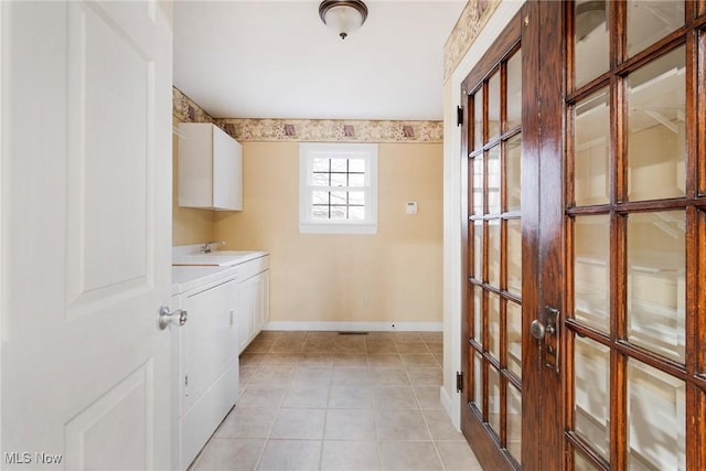 washroom featuring light tile patterned flooring, cabinets, washer / dryer, and sink