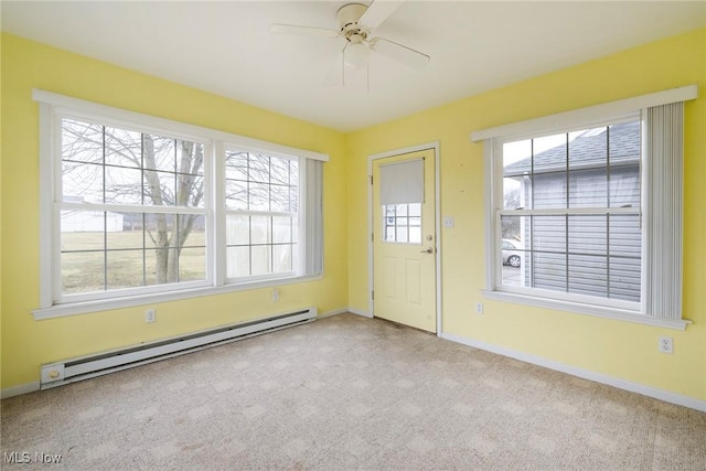 interior space with ceiling fan, light colored carpet, and a baseboard heating unit