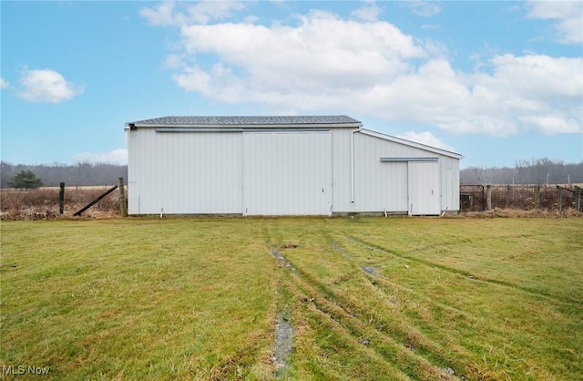 view of outdoor structure with a lawn and a rural view