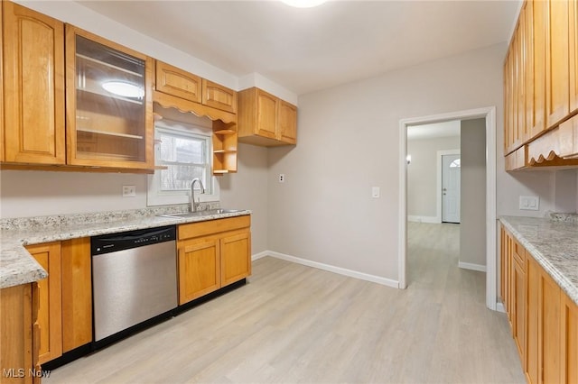 kitchen with light stone counters, sink, light hardwood / wood-style flooring, and stainless steel dishwasher