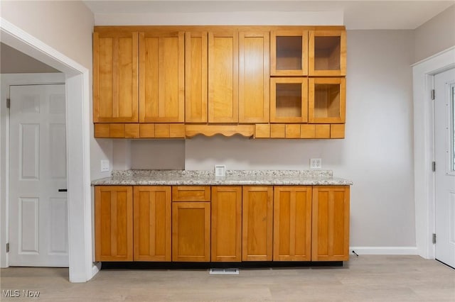 kitchen featuring light stone countertops and light hardwood / wood-style flooring