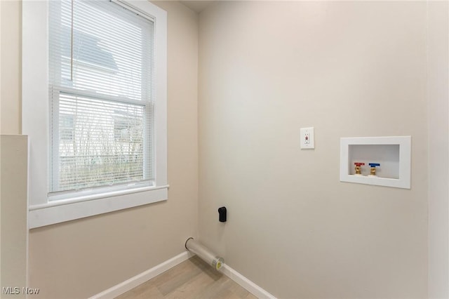 laundry room featuring washer hookup and light hardwood / wood-style flooring