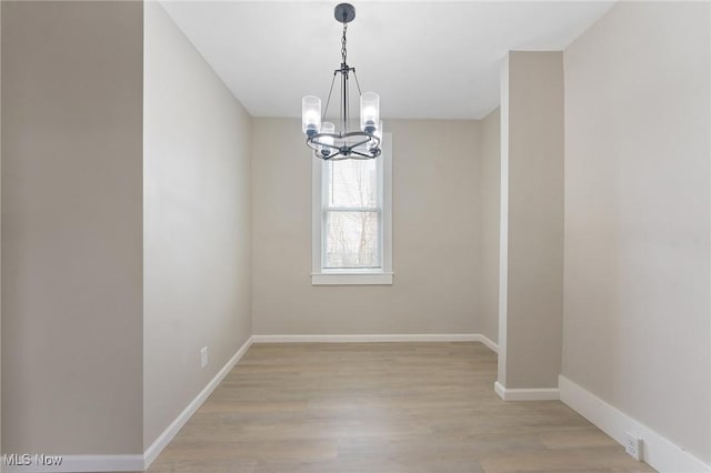 unfurnished dining area featuring an inviting chandelier and light wood-type flooring