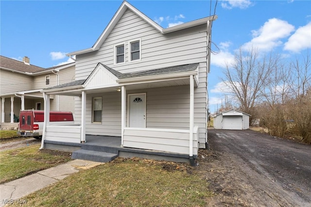 view of front of house with a porch, a garage, a jacuzzi, an outdoor structure, and a front yard