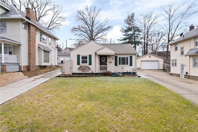 view of front facade with an outbuilding, a garage, and a front lawn