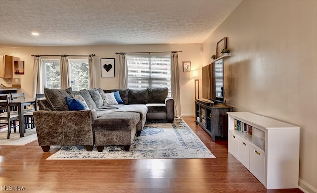 living room with dark hardwood / wood-style flooring and a textured ceiling