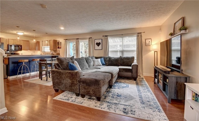 living room featuring a textured ceiling and light hardwood / wood-style floors