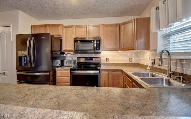 kitchen featuring appliances with stainless steel finishes, sink, a textured ceiling, and decorative backsplash