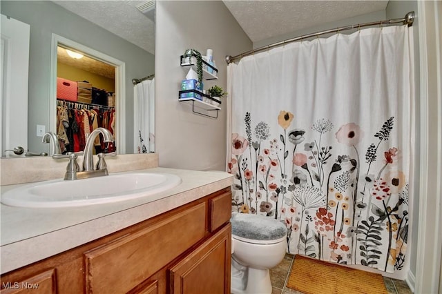 bathroom with vanity, curtained shower, a textured ceiling, and toilet
