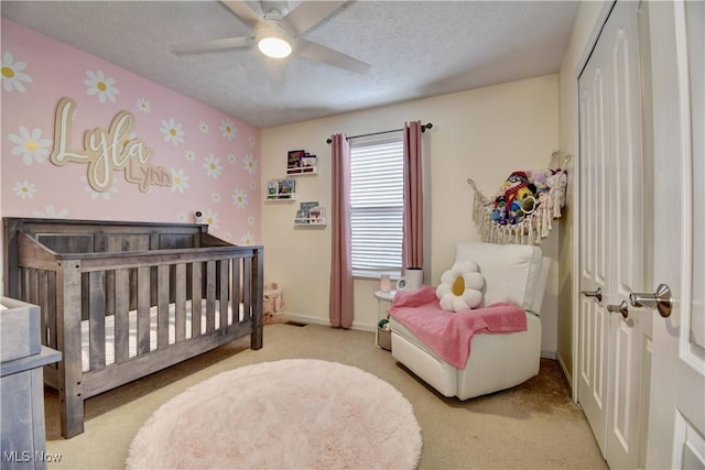 carpeted bedroom featuring ceiling fan, a textured ceiling, and a closet