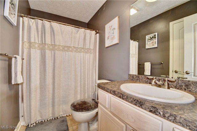 bathroom with vanity, toilet, and a textured ceiling