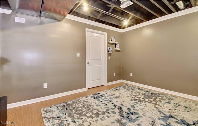 basement with hardwood / wood-style flooring and ornamental molding