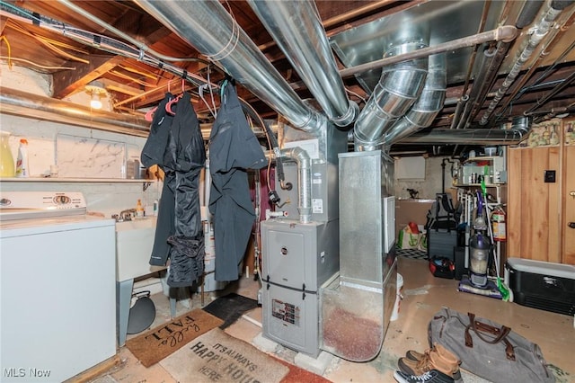 basement with washer / clothes dryer, sink, and heating unit