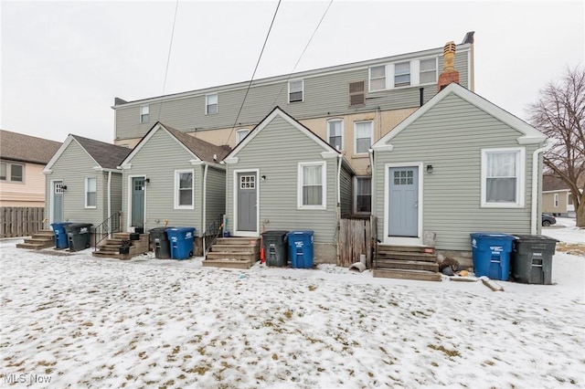 view of snow covered rear of property