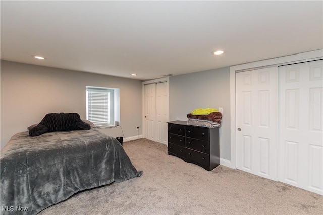 bedroom with multiple closets and carpet